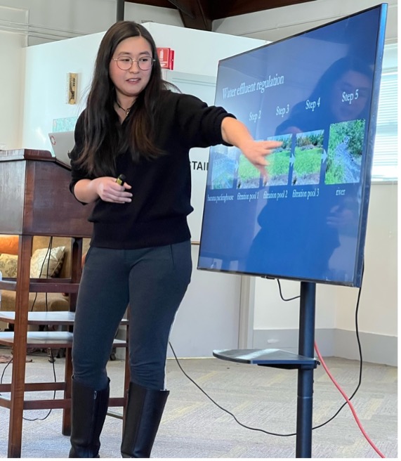 A picture of Alyssa Paredes gesturing to information on a screen during her presentation